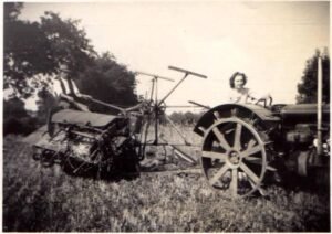 John Padfield on the binder with Doris driving the tractor in 1940