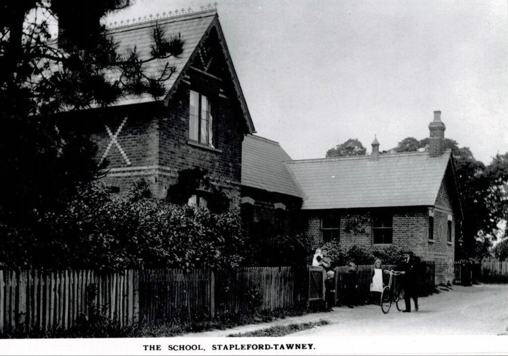 The schoolroom is on the right. On the left is the school house, where the schoolmistress lodged with the Sarling family, some of them shown in this photo of c 1912. The building is still there, next to the church.