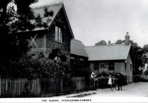 The schoolroom is on the right. On the left is the school house, where the schoolmistress lodged with the Sarling family, some of them shown in this photo of c 1912. The building is still there, next to the church.
