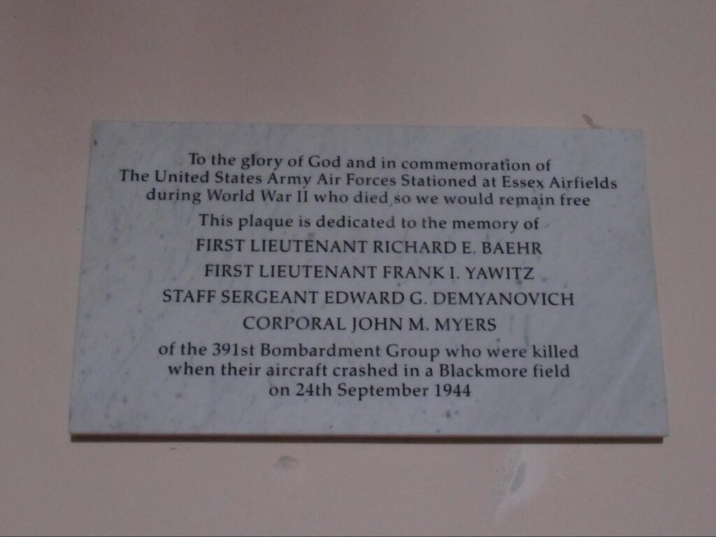 The wording, as commissioned, on the wall mounted plaque reads:
To the glory of God and in commemoration of
The United States Army Air Force Stationed at Essex Airfields
During World War II who died so we would remain free
This plaque is dedicated to the memory of
FIRST LIEUTENANT RICHARD E. BAEHR
FIRST LIEUTENANT FRANK I. YAWITZ
STAFF SERGEANT EDWARD G. DEMYANOVICH
CORPORAL JOHN M. MYERS
Of the 391st Bombardment Group who were killed
When their aircraft crashed in a Blackmore field
On 24th September 1944